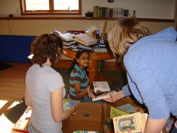 Three girls sorting books