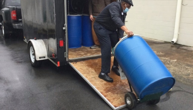 Man pulling a big blue drum