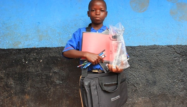 A young boy with his school things