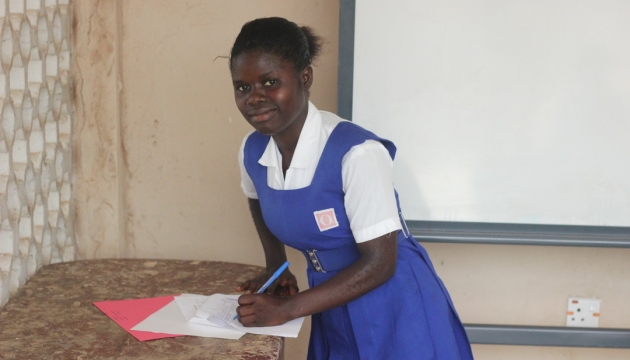 Isata in her uniform writing