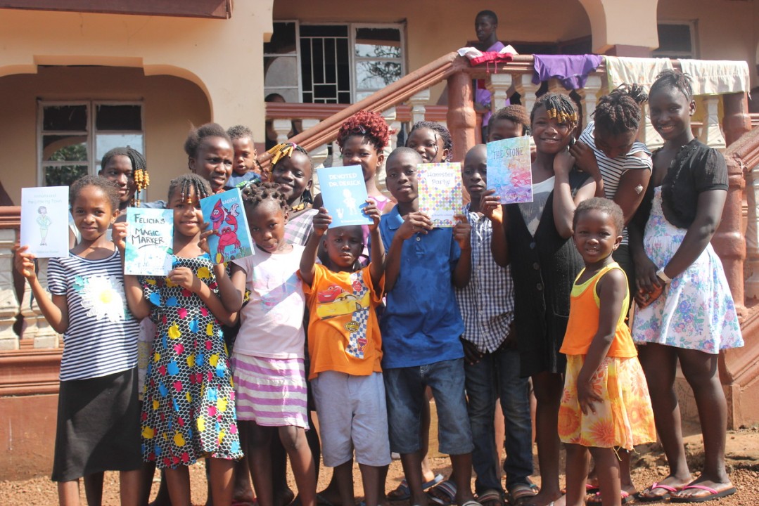 kids with books given to them by develop africa