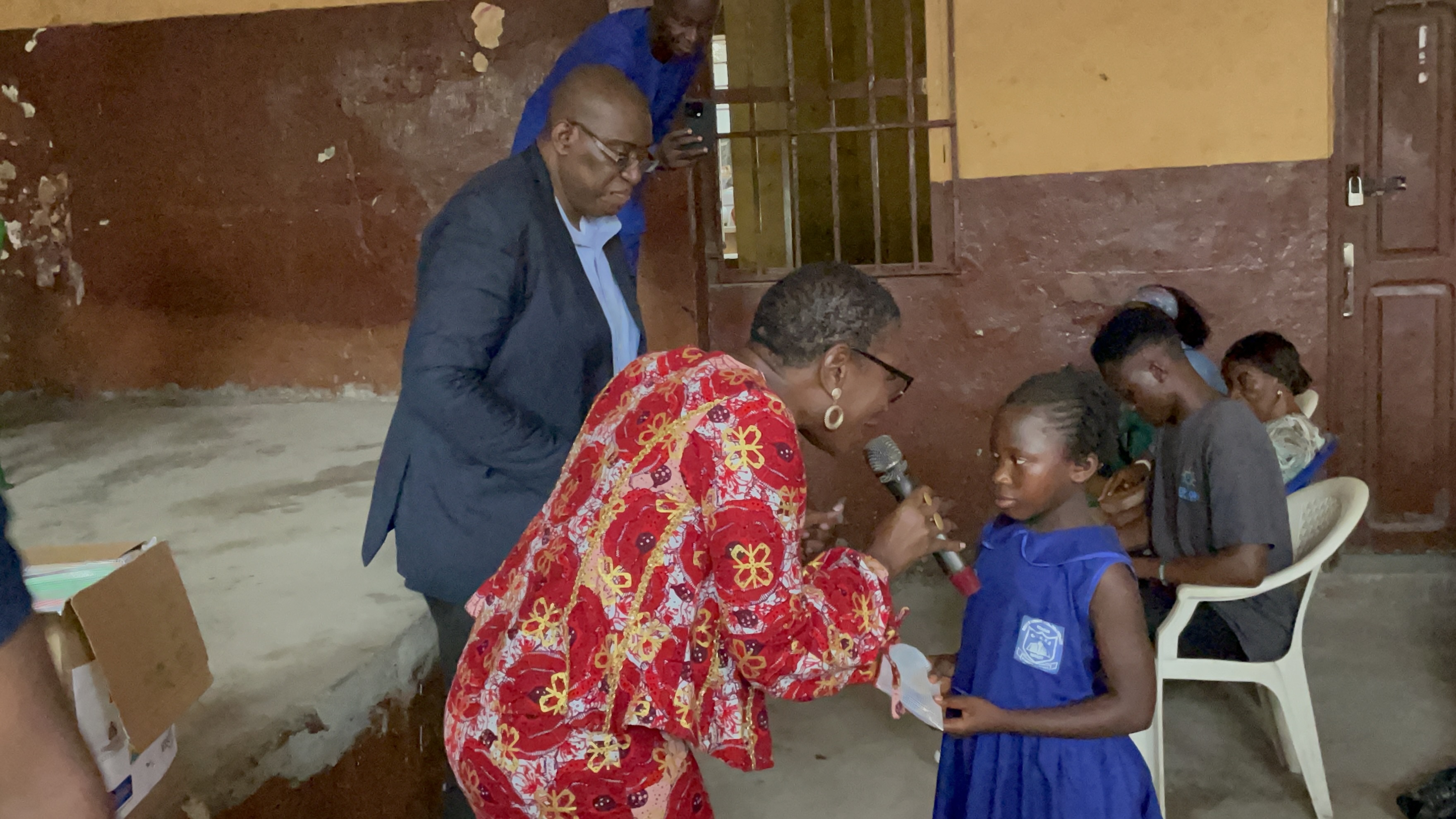 Sylvester and Mayor Yvonne handing a pencil to a kid at the Year of The Pencil Campaign