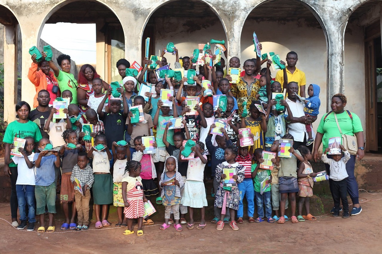 (c) Develop Africa. Students in Cameroon receive school supplies, "One Child, One Pencil."