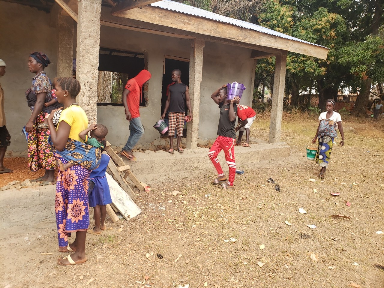 Community members bring in stones and sand for the floor construction.