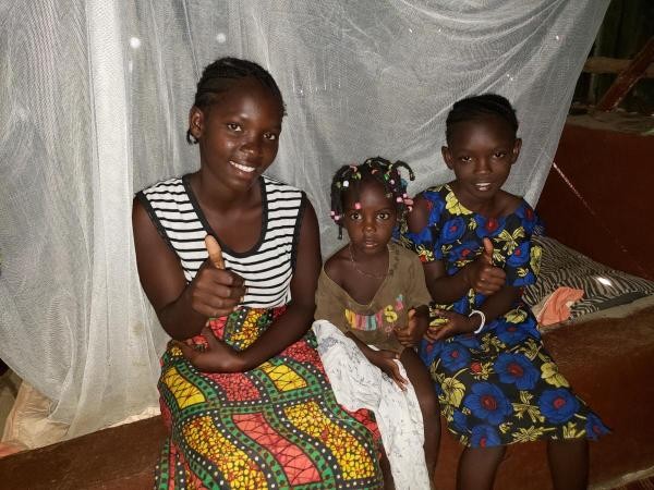 Family using the mosquito net provided by Develop Africa