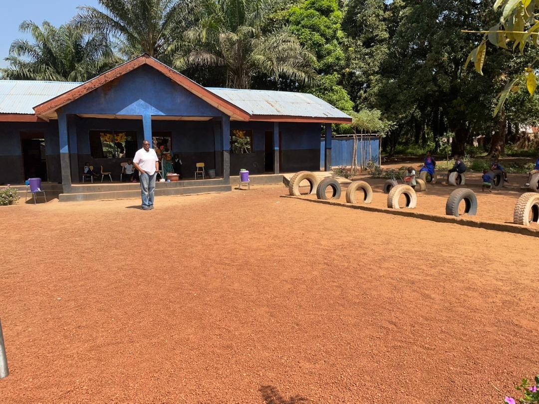 Sylvester standing and smiling on the Kamawornie Nursery School playground